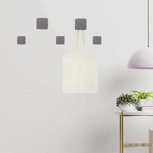 Appendiabiti da parete t.b.t. con cinque ganci quadrati grigi, uno con una borsa di stoffa.