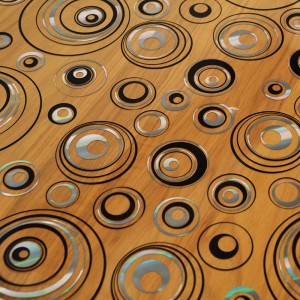 Tovaglia con motivo a cerchi in nero, argento e effetto legno.