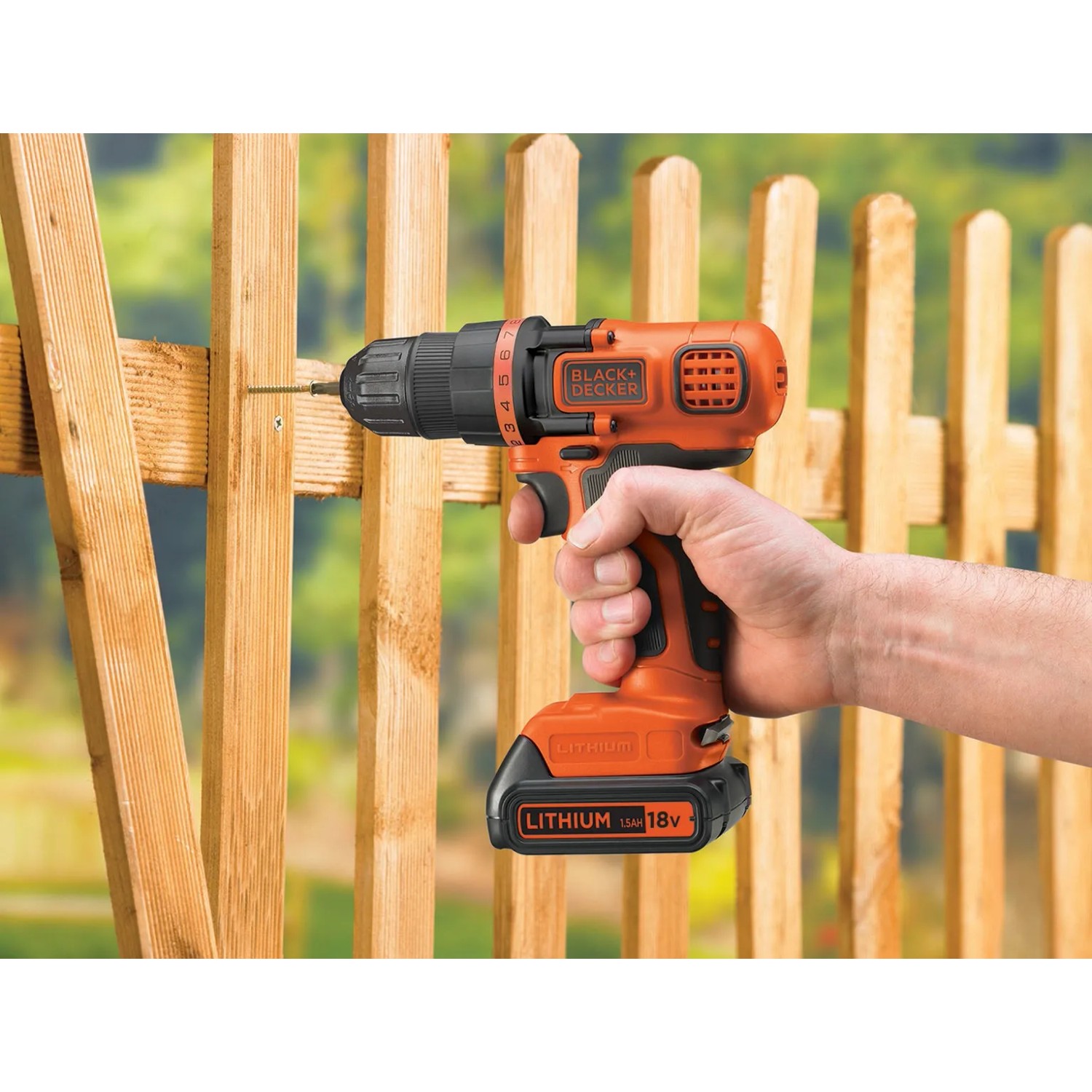 Avvitatore a batteria Black+Decker BDCDD18N avvita in staccionata di legno.