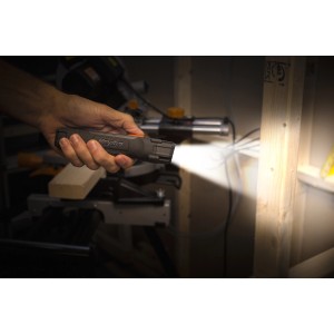 Mano che tiene la torcia t.b.t. Torce, che illumina una tavola di legno.