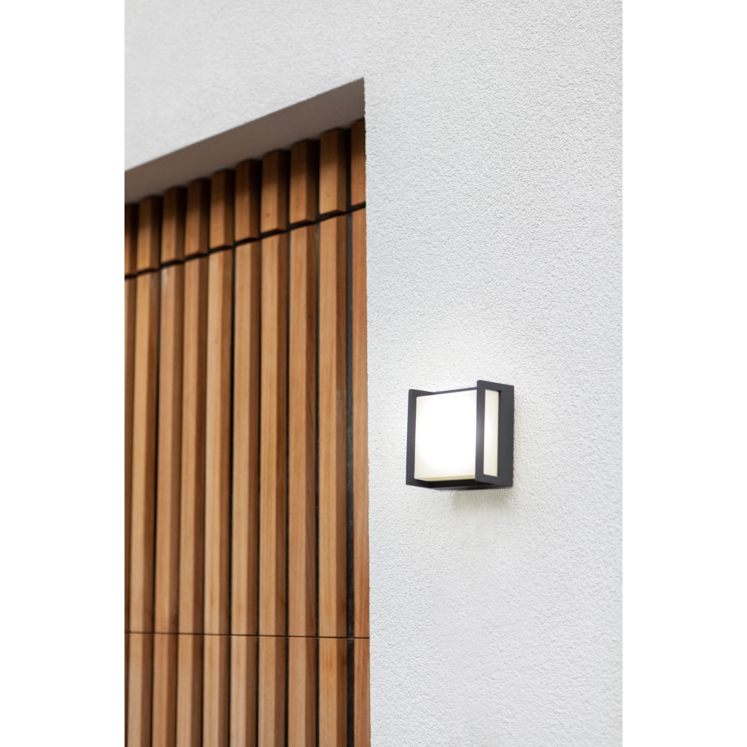 Applique da esterno a LED Lutec Qubo piccola e quadrata color antracite su parete bianca.