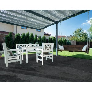 Patio con piastrelle in pietra naturale scura, mobili da giardino bianchi e altalena.