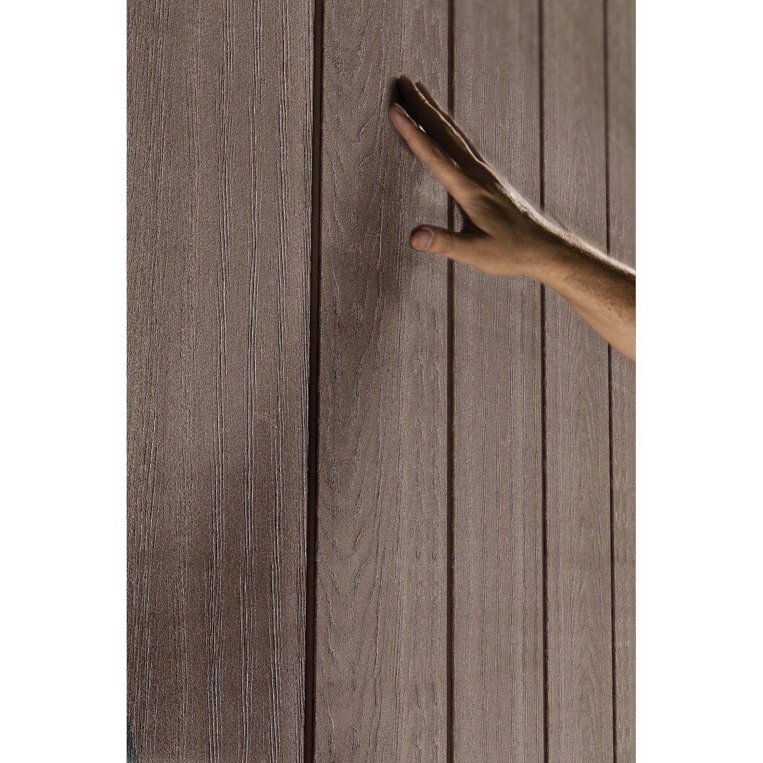 Dettaglio di una parete di casetta da giardino in plastica effetto legno con una mano.