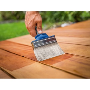 Mano che vernicia il legno con pennello piatto LUX 100 mm con serbatoio. Pennello per vernice.