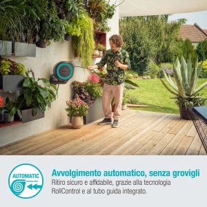 Avvolgitubo a muro con uomo che innaffia il giardino.