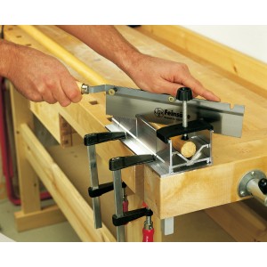 Sega per rifinitura LUX Classic che taglia legno in una cassetta per tronchi su un banco da lavoro.