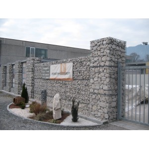 Muro di gabbioni con ciottoli e granulati come schermo per la privacy ed elemento da giardino.