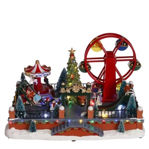 Scena natalizia in miniatura con giostra, ruota panoramica e albero di Natale, decorazione festiva.