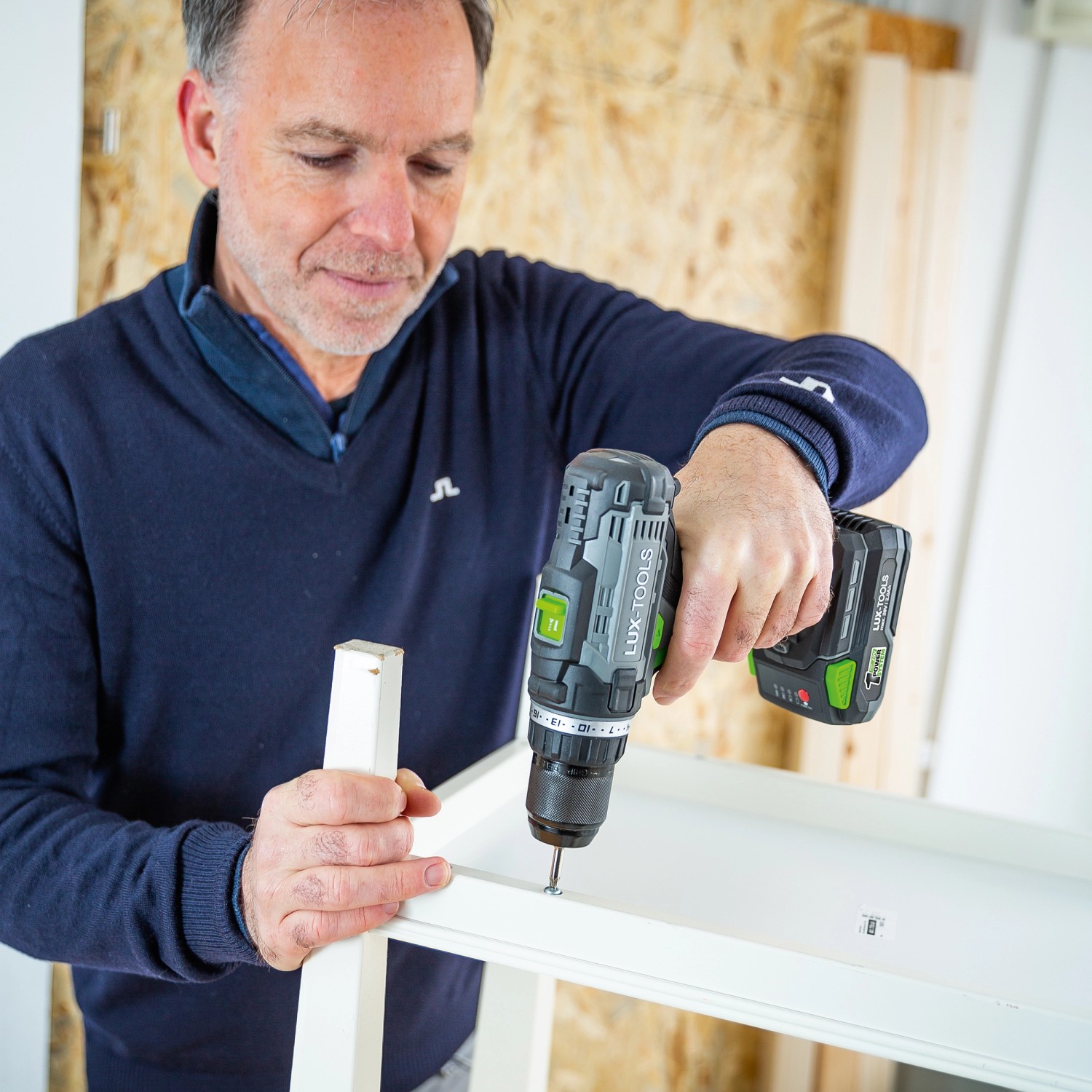 Uomo che assembla mobili con avvitatore a batteria LUX A-BS-20.