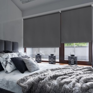 Tende a rullo t.b.t grigie alla finestra della camera da letto. Privacy e decorazione.