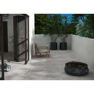 Piastrelle per esterni grigie t.b.t. su una terrazza con area salotto e piante.