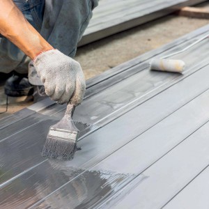 Applicazione di pittura isolante con pennello su superficie in legno.