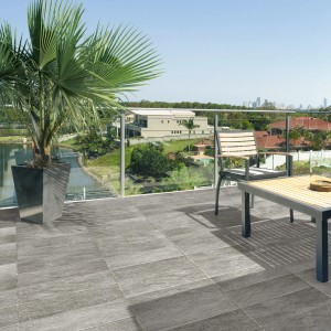 Piastrelle per esterni grigie t.b.t. su una terrazza panoramica con mobili e vista.