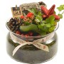 Composizione festiva di piante in vetro con stella, pigna e nastro 'Merry Christmas'.