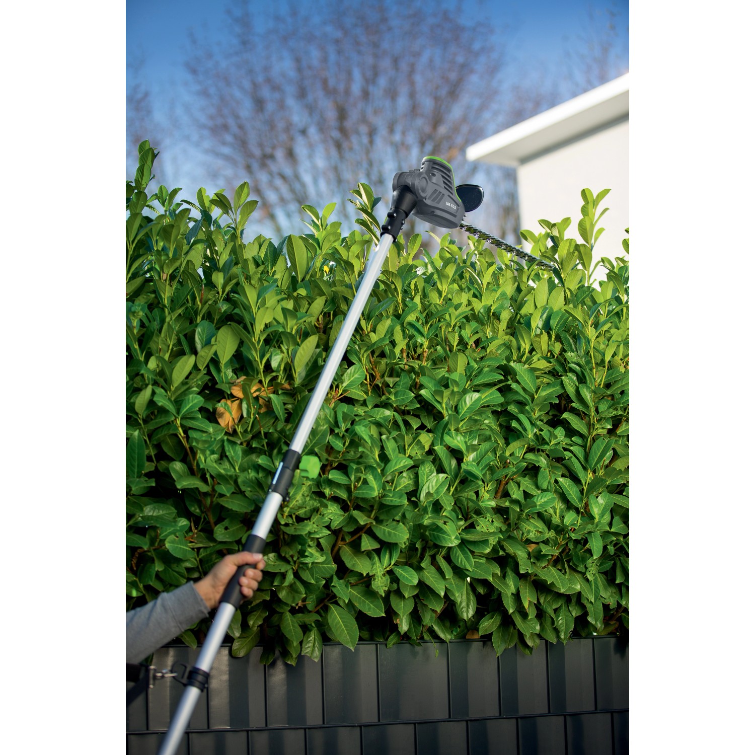 Tagliasiepi a batteria telescopica LUX A-HS-20/51T taglia una siepe.