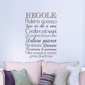 Adesivo murale con testo italiano "Regole" sopra un divano. Decorazione murale per interni.