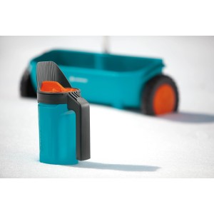 Spargitore manuale Gardena Kleinstreuer S turchese per fertilizzanti e sementi, con spargitore sullo sfondo.