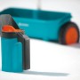 Spargitore manuale Gardena Kleinstreuer S turchese per fertilizzanti e sementi, con spargitore sullo sfondo.