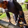 Uomo sega ramo con motosega a una mano Worx Nitro WG325E. Motosega a batteria compatta per giardinaggio.