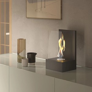 Moderno camino decorativo t.b.t. con fiamma e cornice in vetro come decorazione da tavolo.