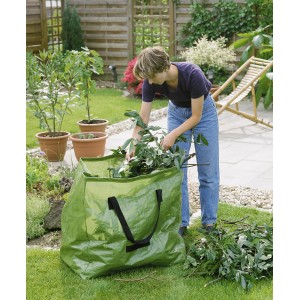 Sacco verde per rifiuti da giardino (245 l) con donna che lo riempie in giardino.