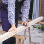 Artigiano che leviga il legno con blocco abrasivo manuale LUX 70x130 mm per risultati precisi.