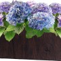 Fioriera marrone (21x21x49,5 cm) con struttura in legno, piantata con ortensie viola e blu.