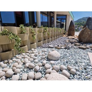 Bordura impilata con piante e pietre decorative in giardino.