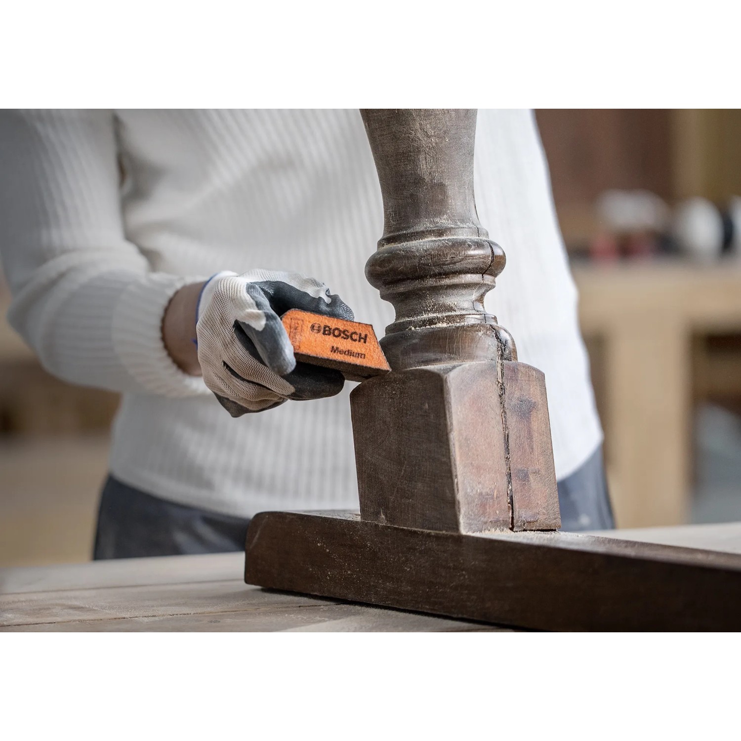 Spugna abrasiva Bosch Expert in uso per levigare il legno.