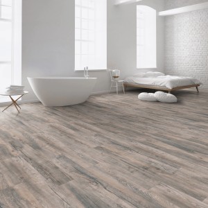 Laminato Kaindl rovere Saloon Tombstone in bagno con vasca e letto sullo sfondo.