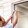 Installazione della tenda magnetica tesa antracite su una porta. Zanzariera per balconi e porte finestre.