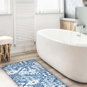 Tappeto da bagno blu e bianco con motivi davanti alla vasca. Zerbini per cucina e bagno.