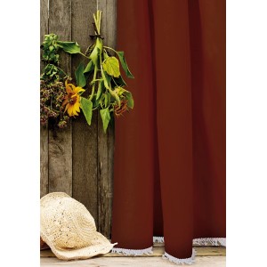 Tenda decorativa t.b.t. bordeaux con bordo frangiato bianco e cappello di paglia davanti a una parete di legno.