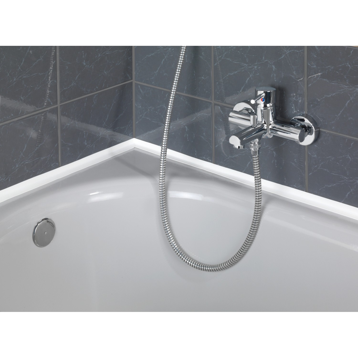 Applicazione del nastro sigillante bianco Wenko su una vasca da bagno con rubinetto e piastrelle grigie.