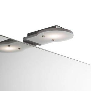 Moderna applique t.b.t. con finitura cromata e illuminazione indiretta sullo specchio.