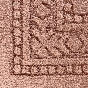 Dettaglio di un tappeto da bagno beige con motivi.