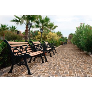 Piastrelle da rivestimento posate su un vialetto da giardino con panchine.