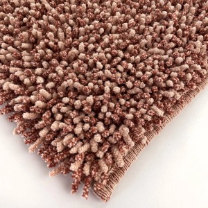 Dettaglio di un tappeto da bagno t.b.t. marrone e beige con texture a ciuffi.