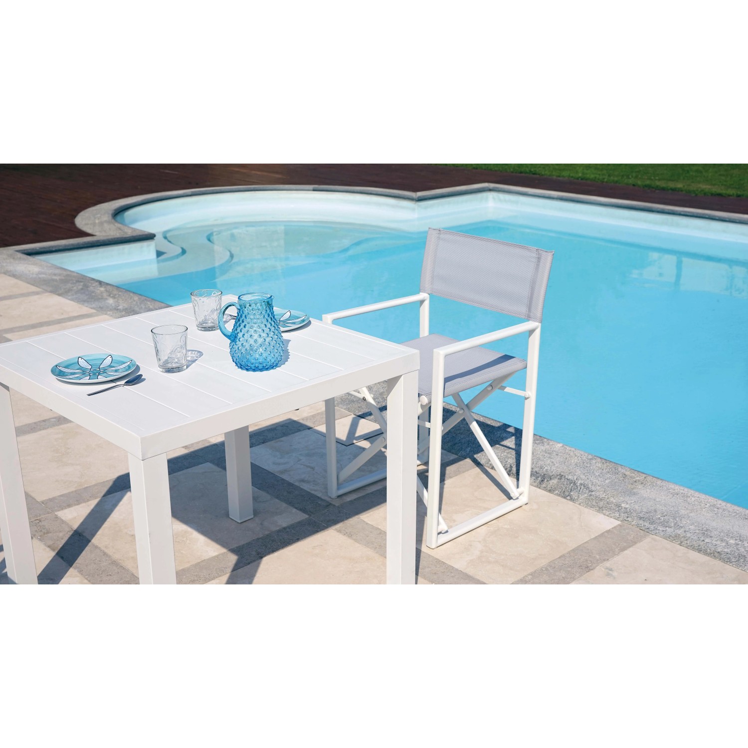 Tavolo da giardino bianco con sedia a bordo piscina. Ideale per il relax all'aperto.