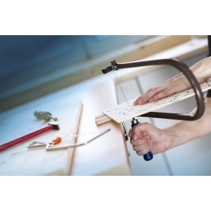 Archetto da traforo LUX Comfort che taglia il legno, attrezzi sullo sfondo.