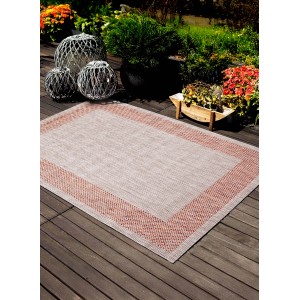 Tappeto da esterno beige con bordo rosso su patio in legno.