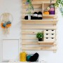 Mensola in legno con cassettiera t.b.t., filati e decorazioni su una parete.