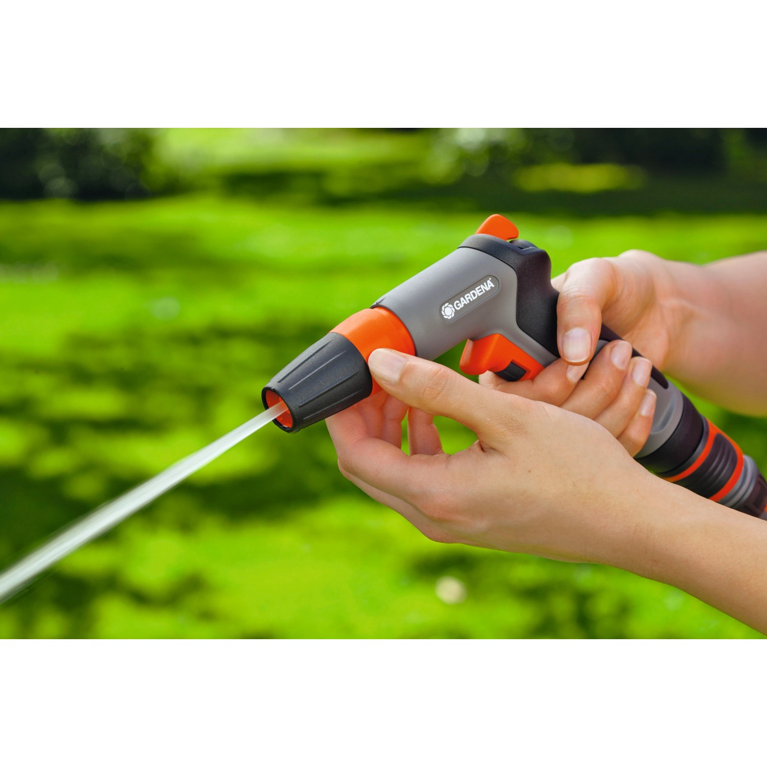 Gardena Lancia per pulizia Classic in azione: spruzzatore da giardino grigio con dettagli arancioni tenuto in mano.