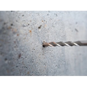 Il trapano a percussione LUX Hammer Classic SDS-Plus fora un muro di cemento.