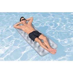 Uomo rilassato su un materassino gonfiabile grigio in piscina.