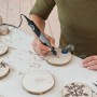 Dremel Stylo+ multiutensile che incide un pezzo di legno.