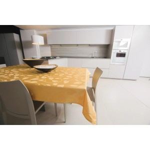 Tovaglia t.b.t. gialla con motivo a foglie su tavolo da pranzo in cucina moderna.