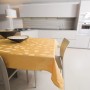Tovaglia t.b.t. gialla con motivo a foglie su tavolo da pranzo in cucina moderna.