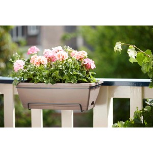 Fioriera da esterno beige con gerani rosa su una ringhiera del balcone.