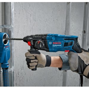 Martello perforatore Bosch Professional GBH 2-21 in uso con aspirazione polvere su una parete.